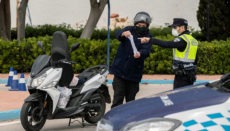 Ein Polizist in Murcia läßt sich die Arbeitsbescheinigung eines Verkehrsteilnehmers zeigen. Foto: EFE