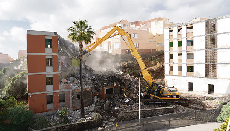 Ein riesiger Abbruchbagger wurde von Gran Canaria nach Teneriffa gebracht, um die fünfstöckigen Wohnhäuser abzureißen. Die Arbeiten gehen schneller voran als angenommen, und es wurden bereits fünf Gebäude abgerissen.