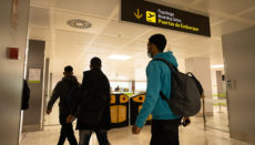 Drei Migranten auf dem Weg zum Flugzeug, das sie auf das spanische Festland bringen wird. Foto: EFE